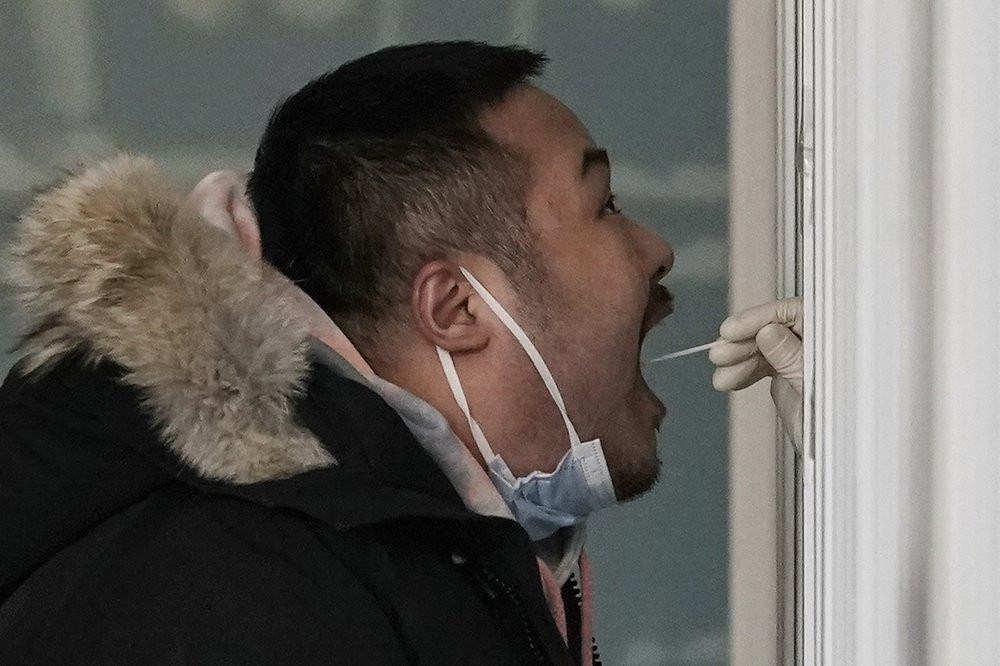 A man gets a swab for the coronavirus test at a hospital in Beijing, Sunday, Jan. 17, 2021.
