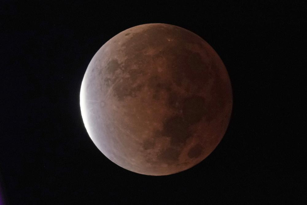 The earth's shadow covers the full moon during a partial lunar eclipse, early Friday, Nov. 19, 2021, in Kansas City, Missouri.