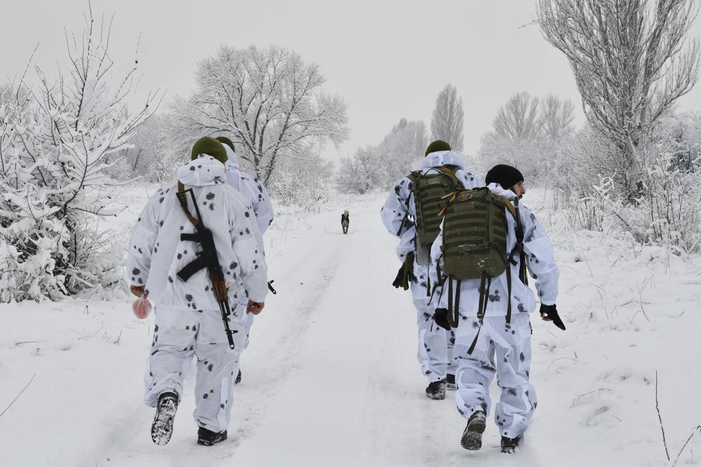 Ukrainian servicemen walk to their position at the frontline with with Russia-backed separatists outside Verkhnotoretske village in Yasynuvata district of Donetsk region, eastern Ukraine, Dec. 27, 2021.