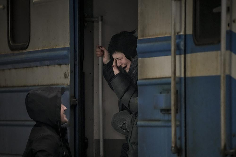 A woman on a Lviv bound train cries while she bids goodbye to a man in Kyiv, Ukraine, Saturday, March 12, 2022. Fighting raged in the outskirts of Ukraine's capital, Kyiv, and Russia kept up its bombardment of other resisting cities.