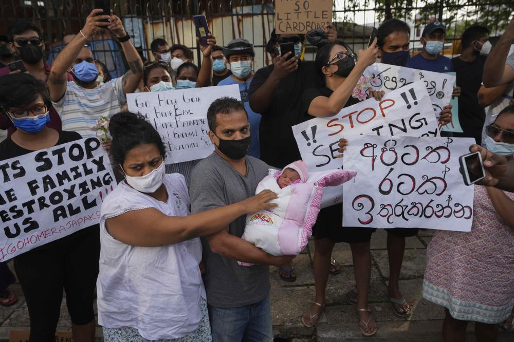 A Sri Lankan couple with their infant join an anti government protest during a curfew in Colombo, Sri Lanka, Sunday, April 3, 2022.