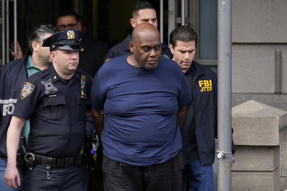 New York City Police and law enforcement officials lead subway shooting suspect Frank R. James, 62, center, away from a police station, in New York, Wednesday, April 13, 2022.