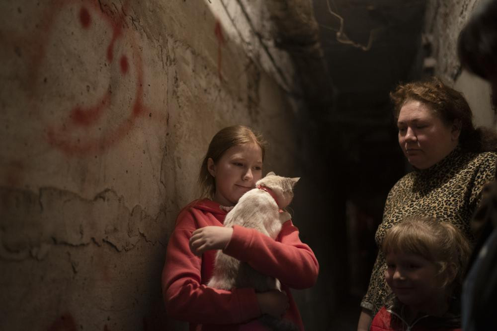 Elizabeth, 12, holds her cat as she takes shelter with her family inside the basement of a residential building during a Russian attack in Lyman, Ukraine, Tuesday, April 26, 2022.