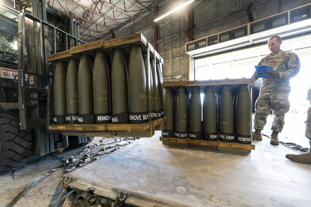 U.S. Air Force Staff Sgt. Cody Brown, right, with the 436th Aerial Port Squadron, checks pallets of 155 mm shells ultimately bound for Ukraine, Friday, April 29, 2022, at Dover Air Force Base, Delaware.