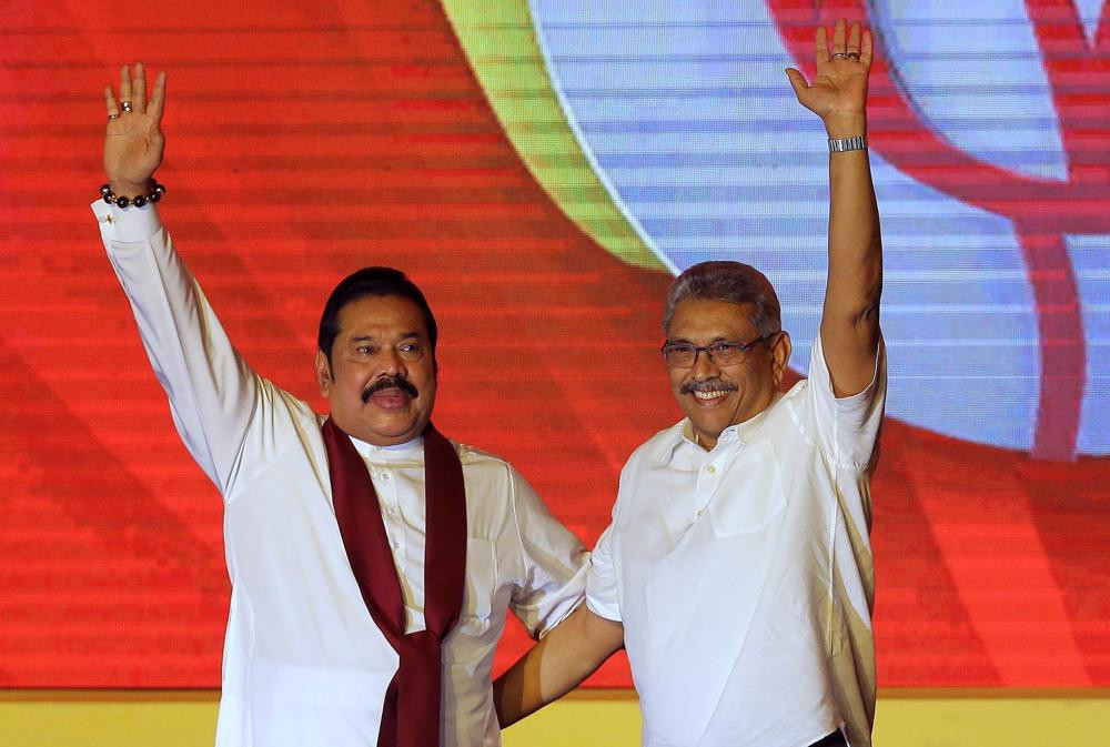 FILE - Mahinda Rajapaksa, left, and his brother Gotabaya Rajapaksa wave to supporters during a party convention held to announce the presidential candidacy in Colombo, Sri Lanka, Aug. 11, 2019.