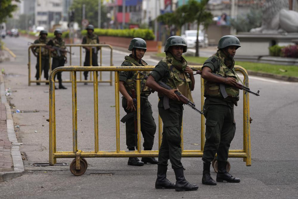 Sri Lankan army soldiers guard a check point outside prime minister's residence a day after clashes between government supporters and anti-government protesters in Colombo, Sri Lanka, Tuesday, May 10, 2022.