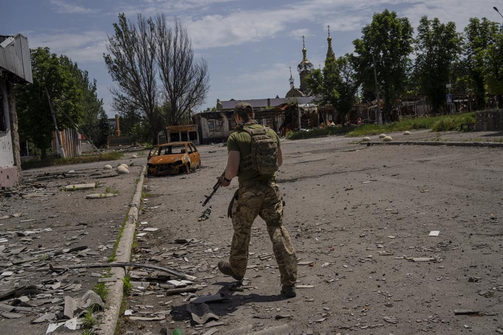 A Ukrainian serviceman patrols a village near the frontline in the Donetsk oblast region, eastern Ukraine, Thursday, June 2, 2022.