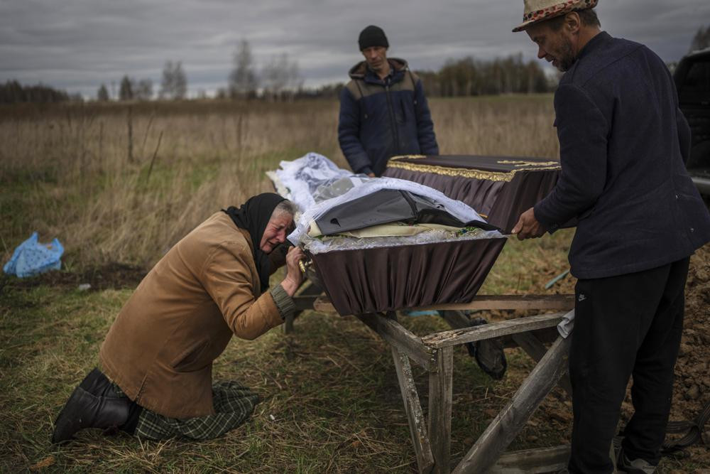 FILE - Nadiya Trubchaninova cries over the coffin of her son, Vadym, who was killed on March 30 by Russian soldiers in Bucha, Ukraine, during his funeral in the cemetery of nearby Mykulychi, on the outskirts of Kyiv, on April 16, 2022.