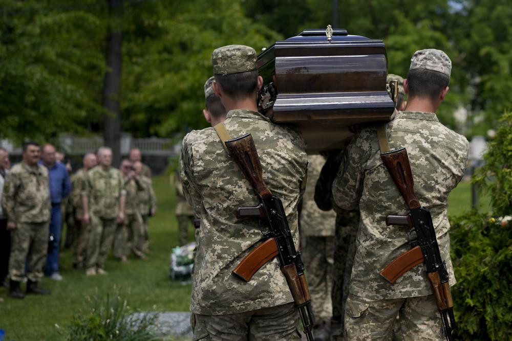 Ukrainian servicemen carry the coffin with the remains of Army Col. Oleksander Makhachek during his funeral in Zhytomyr, Ukraine, Friday, June 3, 2022.