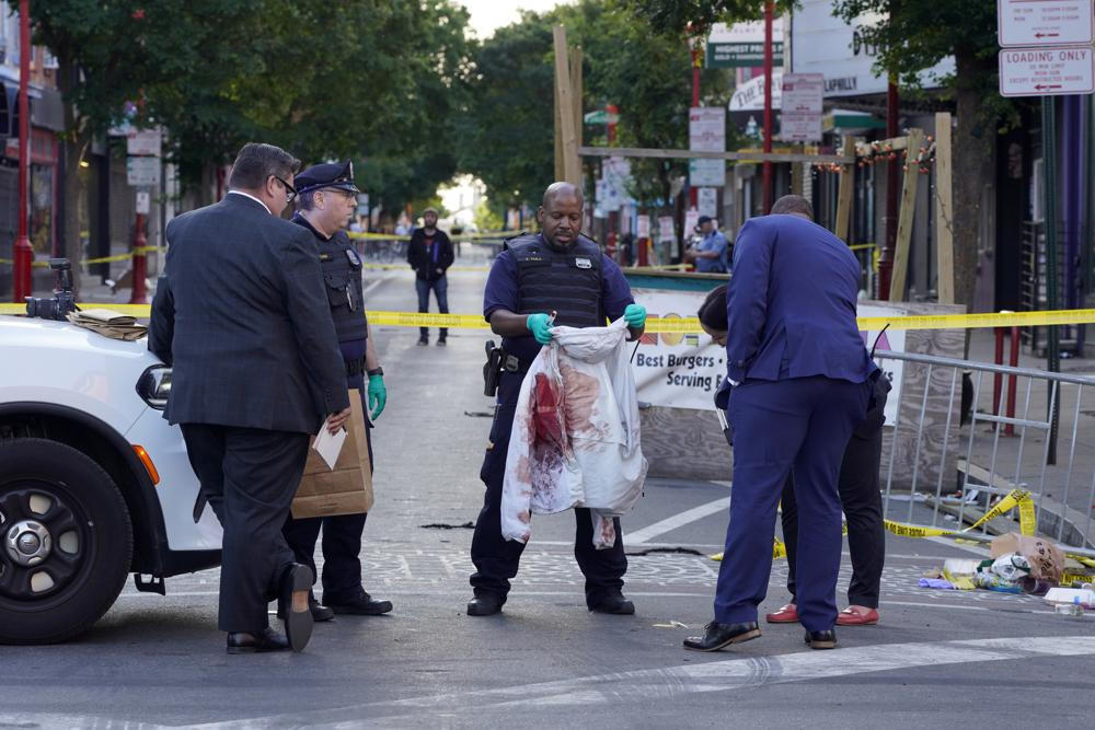 Philadelphia Police investigators work the scene of a fatal overnight shooting on South Street in Philadelphia, Sunday, June 5, 2022.