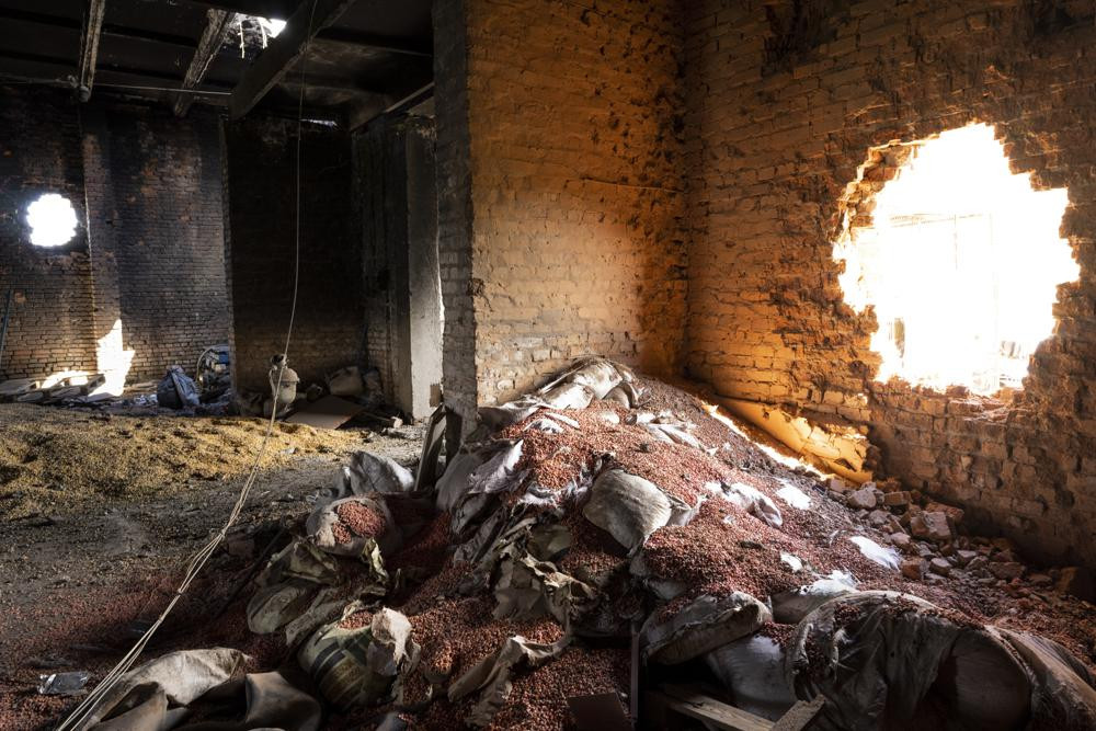 FILE - Scattered grain sits inside a warehouse damaged by Russian attacks in Cherkaska Lozova, outskirts of Kharkiv, eastern Ukraine, May 28, 2022.
