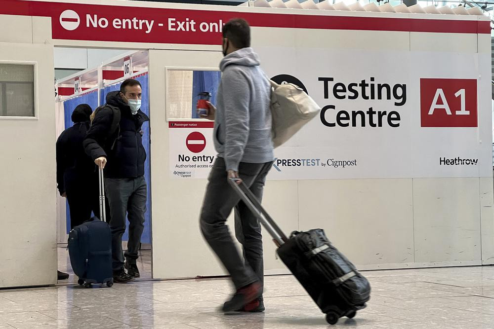 FILE - Passengers get a COVID-19 test at Heathrow Airport in London, Nov. 29, 2021.