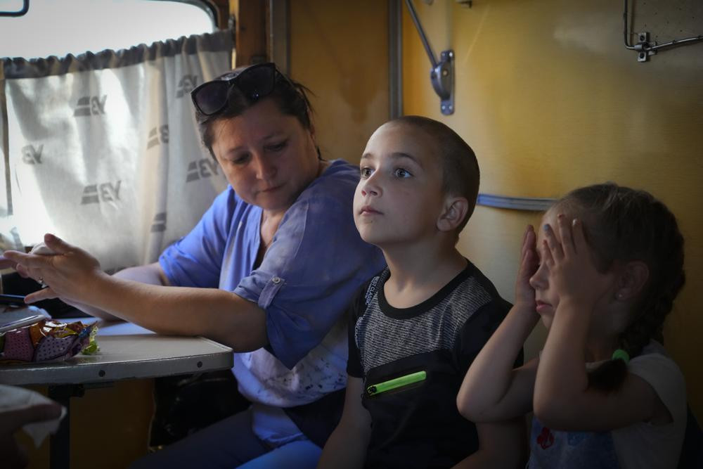 People evacuated from the war hit area sit inside an evacuation train waiting for departure in Pokrovsk, eastern Ukraine, Saturday, June 11, 2022.