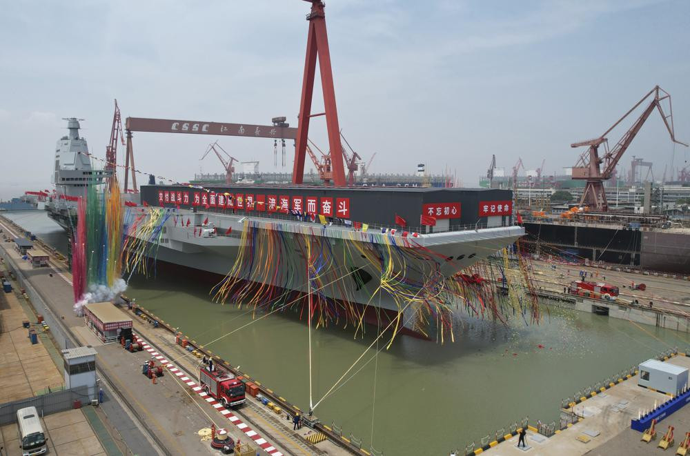 In this photo released by Xinhua News Agency, coloured smoke mark the launch ceremony for China's third aircraft carrier christened Fujian at a dry dock in Shanghai on Friday, June 17, 2022.