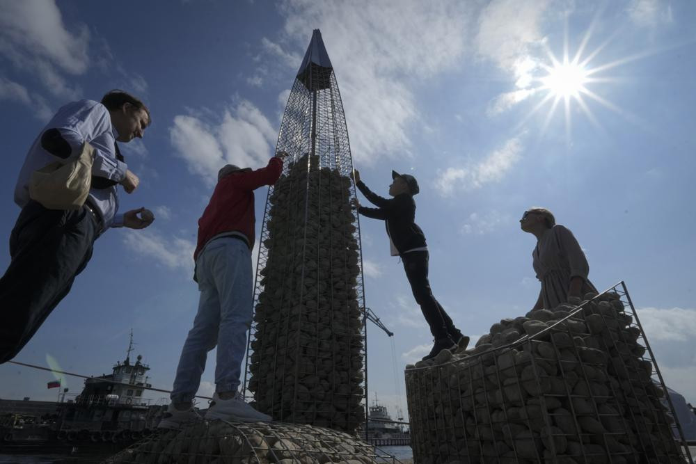 FILE - People build a model of the business tower Lakhta Centre, at the headquarters of Russian gas monopoly Gazprom, filling the frame with stones, in St. Petersburg, Russia, Thursday, June 9, 2022. AP/RSS Photo