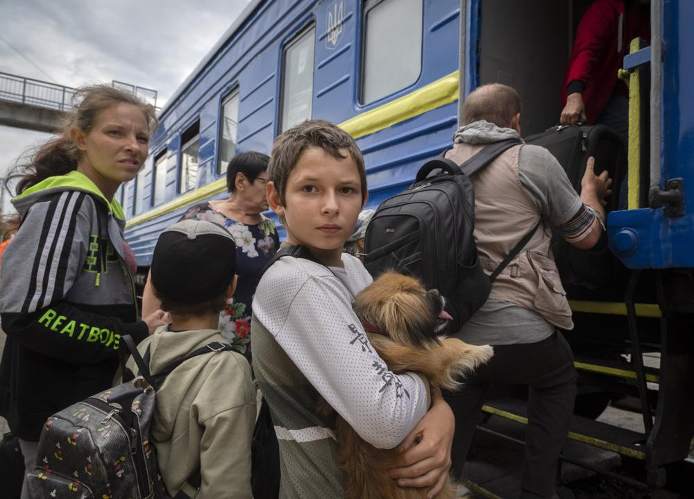 A boy holds his pet dog as his family evacuated from the war-hit area gets on an evacuation train in Pokrovsk, eastern Ukraine, Saturday , June 25, 2022. AP/RSS Photo