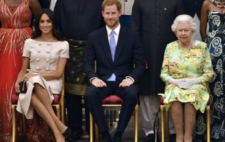 In this Tuesday, June 26, 2018 file photo Britain's Queen Elizabeth, Prince Harry and Meghan, Duchess of Sussex pose for a group photo at the Queen's Young Leaders Awards Ceremony at Buckingham Palace in London.