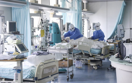 In this Feb. 13, 2020 photo released by China's Xinhua News Agency, nurses in protective suits treat a patient in the intensive care unit at Ditan Hospital in Beijing, one of the hospitals in China's capital that are receiving COVID-19 patients.
