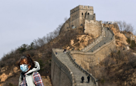 A woman wearing a protective face mask visits the Badaling Great Wall of China after it reopened for business following the new coronavirus outbreak in Beijing, China, Tuesday, March 24, 2020.