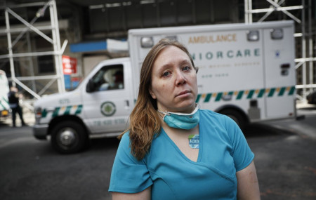 Registered Nurse Elizabeth Schafer, 36, of South St. Paul, Minn., stands for a portrait before entering Beth Israel Mount Sinai Hospital for her second day volunteering to combat the COVID-19 pandemic, Wednesday, April 1, 2020, in New York.
