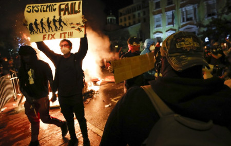 Demonstrators protest the death of George Floyd, Sunday, May 31, 2020, near the White House in Washington. Floyd died after being restrained by Minneapolis police officers.