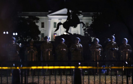 With the White House in the background, a line of police forms behind a fence in Lafayette Park as demonstrators gather to protest the death of George Floyd, Tuesday, June 2, 2020, in Washington.