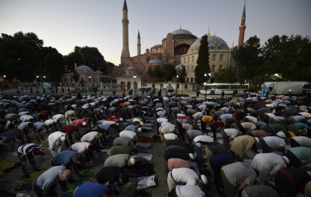 Muslims offer their evening prayers outside the Byzantine-era Hagia Sophia, one of Istanbul's main tourist attractions in the historic Sultanahmet district of Istanbul, following Turkey's Council of State's decision, Friday, July 10, 2020.