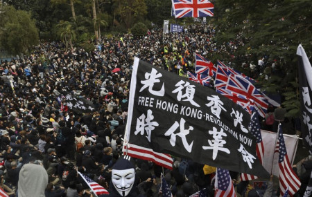 In this Sunday, Jan. 19, 2020 file photo, participants wave British and U.S. flags during a rally demanding electoral democracy and call for boycott of the Chinese Communist Party and all businesses seen to support it in Hong Kong.