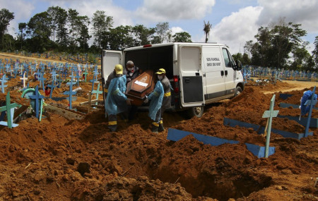 In this Jan. 6, 2021, file photo, cemetery workers carry the remains of 89-year-old Abilio Ribeiro, who died of the coronavirus, to bury at the Nossa Senhora Aparecida cemetery in Manaus, Amazonas state, Brazil.