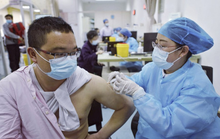 A man wearing a face mask to help curb the spread of the coronavirus receives a shot of Sinovac COVID-19 vaccine at a community health center in Hangzhou in east China's Zhejiang province on Monday, March 15, 2021.