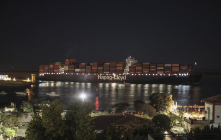 A cargo ship sails through the town of Suez, Egypt, Tuesday, March 30, 2021 as traffic resumed through the Suez canal after it was blocked by a massive ship that had been stuck sideways for nearly a week.