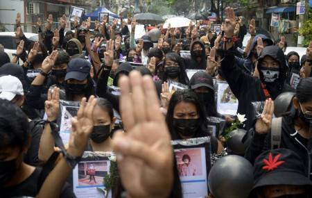 Anti-coup protesters flash three-fingered symbol of resistance as they gather to pray for those who died during a protest against the military in Yangon, Myanmar, Monday, April 5, 2021.