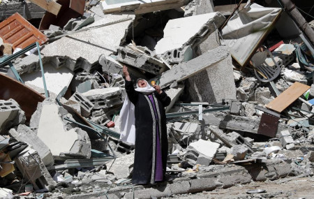 A woman reacts while standing near the rubble of a building that was destroyed by an Israeli airstrike on Saturday that housed The Associated Press, broadcaster Al-Jazeera and other media outlets, in Gaza City, Sunday, May 16, 2021.