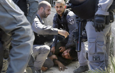 Israeli police officers detain a Palestinian man during clashes that erupted ahead of a planned march by Jewish ultranationalists through east Jerusalem, outside Jerusalem's Old City, Tuesday, June 15, 2021.