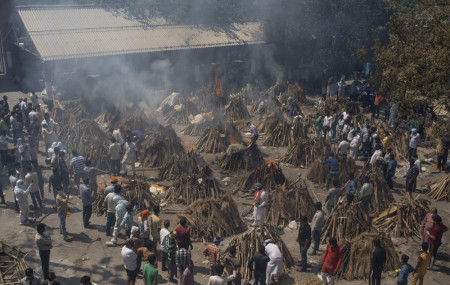 In this April 24, 2021, file photo, multiple funeral pyres of those who died of COVID-19 burn at a ground that has been converted into a crematorium for the mass cremation of coronavirus victims, in New Delhi, India.