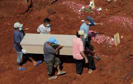 Workers carry a coffin for burial at the special section of Jombang Public Cemetery reserved for those who died of COVID-19, in Tangerang, on the outskirts of Jakarta, Indonesia, Wednesday, Aug. 4, 2021.