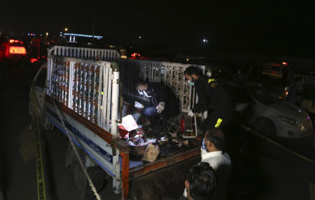 Pakistani investigators examine a truck at the site of an explosion, in Karachi, Pakistan, Saturday, Aug. 14, 2021.