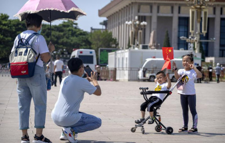 Children hold Chinese flags as they pose for a photo at Tiananmen Square in Beijing, on June 22, 2021.
