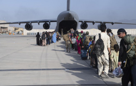 U.S. Air Force loadmasters and pilots assigned to the 816th Expeditionary Airlift Squadron, load people being evacuated from Afghanistan onto a U.S. Air Force C-17 Globemaster III at Hamid Karzai International Airport in Kabul on Tuesday.