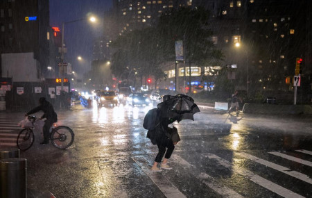 Pedestrians take cover near Columbus Circle in New York Wednesday, Sept. 1, 2021, as the remnants of Hurricane Ida remained powerful while moving along the Eastern seaboard.