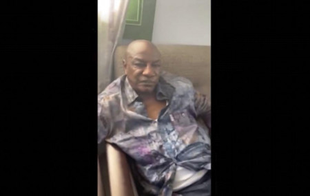 In this image made from video on Sunday, Sept. 5, 2021, Guinean President Alpha Conde sits on a sofa in an unknown location.