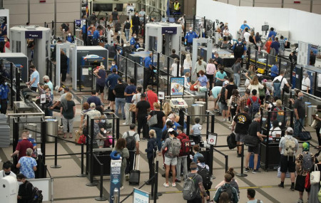 Travelers wear face coverings in the line for the north security checkpoint in the main terminal of Denver International Airport Tuesday, Aug. 24, 2021, in Denver.
