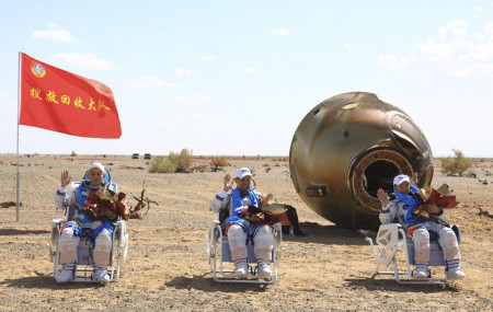 In this photo released by Xinhua News Agency, Chinese astronauts from left, Tang Hongbo, Nie Haisheng and Liu Boming wave at the Dongfeng landing site in northern China's Inner Mongolia Autonomous Region on Friday, Sept. 17, 2021.