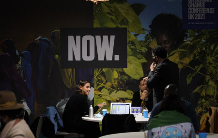 People gather gather at a table inside the venue of the COP26 U.N. Climate Summit in Glasgow, Scotland, Nov. 2, 2021.