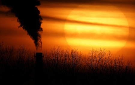 Emissions from a coal-fired power plant are silhouetted against the setting sun, Monday, Feb. 1, 2021, in Kansas City, Missouri.