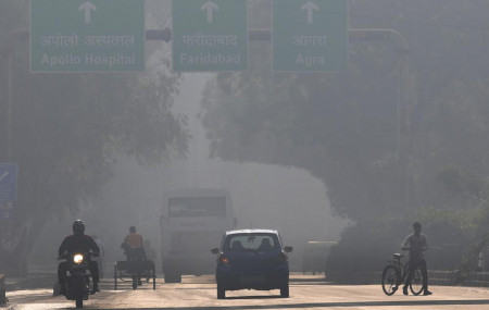 A motorcyclist drives on the wrong side of the road amidst morning haze and toxic smog in New Delhi, India, Wednesday, Nov. 17, 2021.