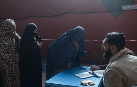 An Afghan woman resisters her name to receive cash at a money distribution center, organized by the World Food Program in Kabul, Afghanistan on Wednesday, Nov. 17, 2021.