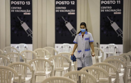 A worker disinfects chairs at a new vaccination center in Lisbon, Tuesday, Nov. 30, 2021.