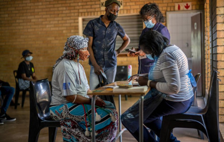 People are processed before receiving their jab against COVID-19 Friday Dec. 3, 2021 at the Orange Farm, South Africa, multipurpose center.