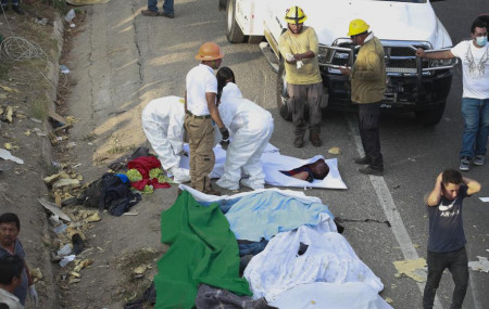 Bodies in bodybags are placed on the side of the road after an accident in Tuxtla Gutierrez, Chiapas state, Mexico, Thursday, Dec. 9, 2021.